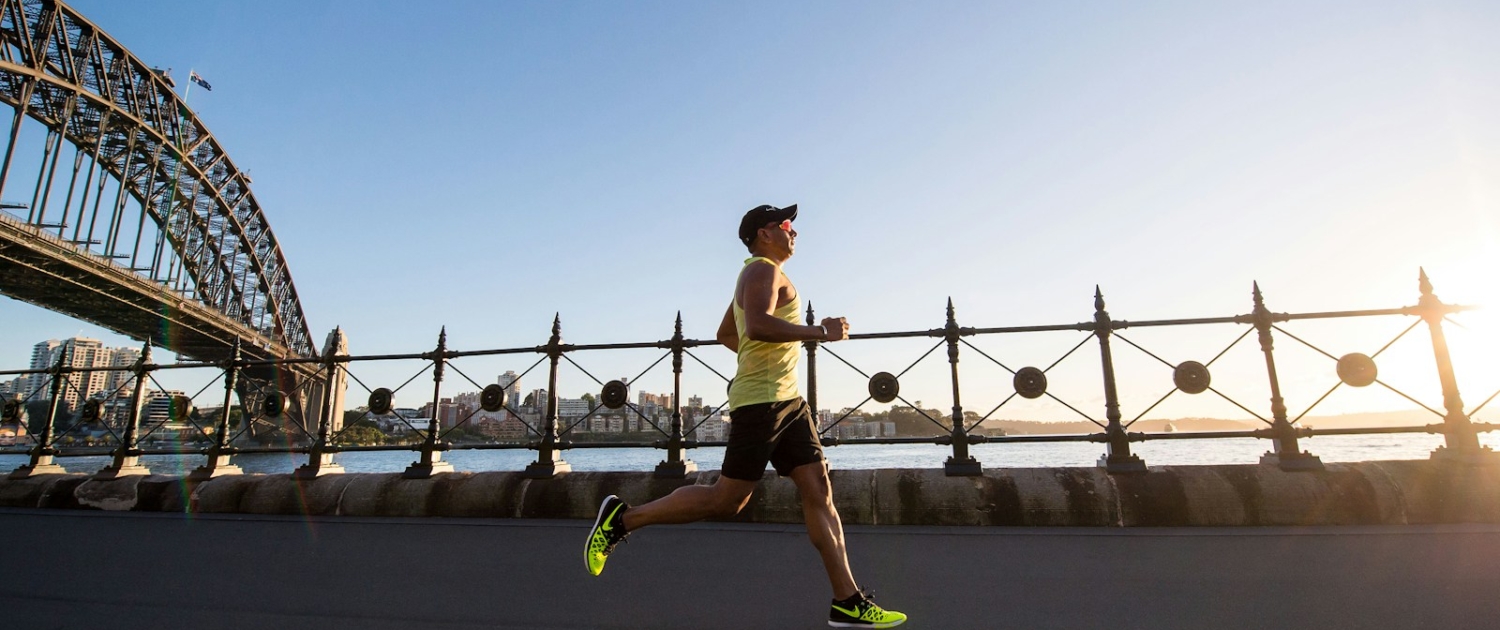 man in yellow tank top running near shore